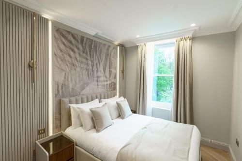 a bedroom with a white bed and a window at Holland Park Residence in London