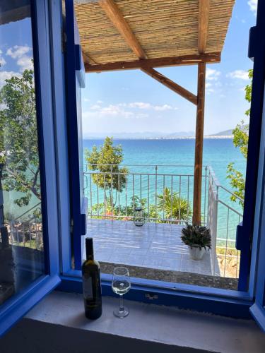 a window with a wine glass and a view of the ocean at Rocksecret Edge in Kalamata