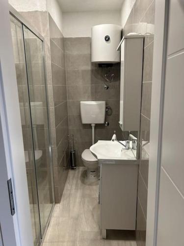 a bathroom with a toilet and a sink and a shower at Apartman Kastel in Kaštela