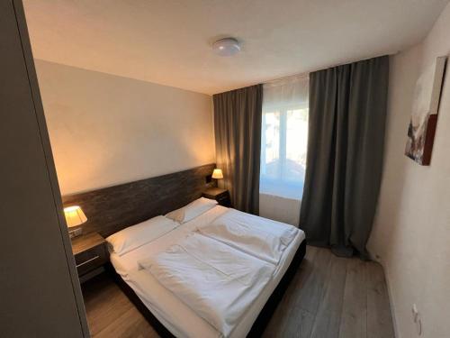 a bedroom with a white bed and a window at Altstadt Hotel Schwanen in Waldshut-Tiengen