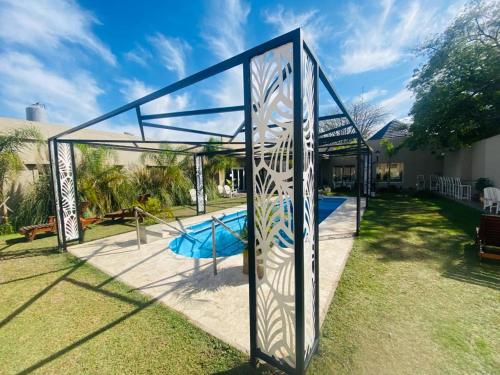 um pavilhão de vidro com um escorrega no quintal em Hotel Suiza em Termas de Rio Hondo