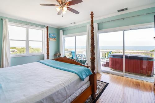 a bedroom with a bed with a view of the ocean at Ocean Queen in Tybee Island