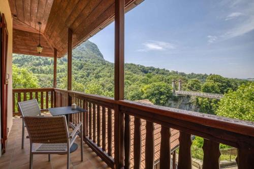 une terrasse couverte avec des chaises et une table et une vue sur la montagne. dans l'établissement Auberge du pont de l'Abîme, à Gruffy