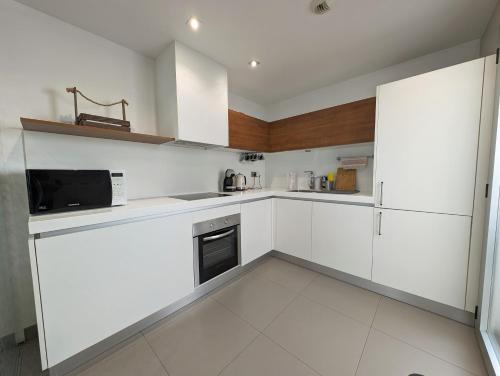 uma cozinha branca com armários brancos e um micro-ondas em Apartments 1418 San Pedro em Marbella