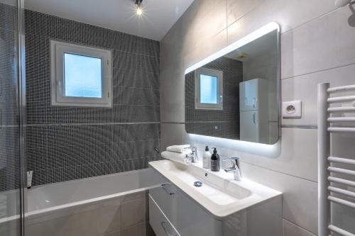 une salle de bain blanche avec un lavabo et un miroir dans l'établissement Magnifique maison avec jardin et salle de jeux proche Paris, à Villejuif