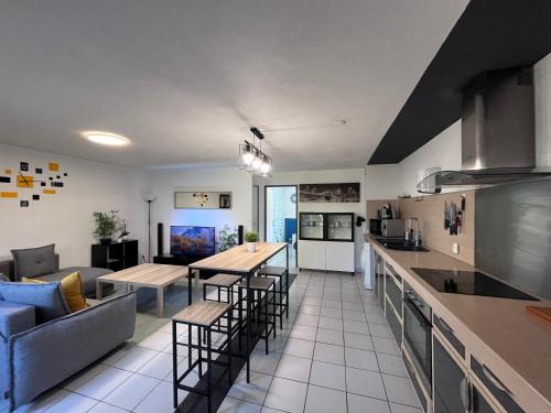 a kitchen and living room with tables and a couch at Grand Appartement T2, charmant jardin in Montpellier