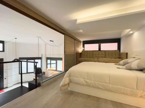 a bedroom with a large white bed and some windows at Loft Rambla in Santa Cruz de Tenerife