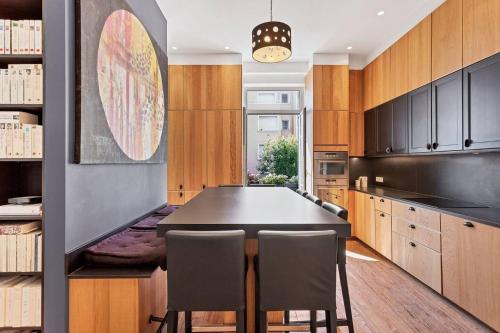 a kitchen with a black table and chairs at Elegant Bel Epoque Apartment In Center Of Menton in Menton