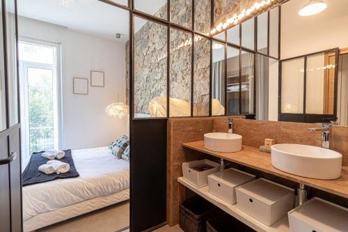 un bagno con due lavandini e un letto di Elegant Bel Epoque Apartment In Center Of Menton a Mentone
