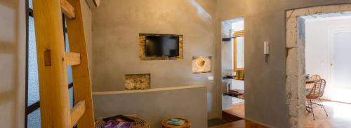 een woonkamer met een tv en een muur bij San Giuseppe apartment con Terrazza in Siracusa