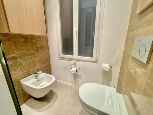 a bathroom with a toilet and a sink and a window at Elegant Bel Epoque Apartment In Center Of Menton in Menton