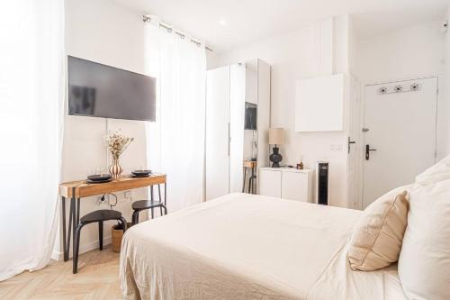 a white bedroom with a bed and a desk at Nice Studio Close To Monaco in Beausoleil