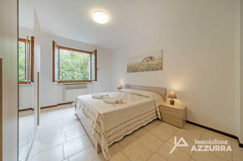 a bedroom with a bed and a window at Casa Ruby - Immobiliare Azzurra in Lazise