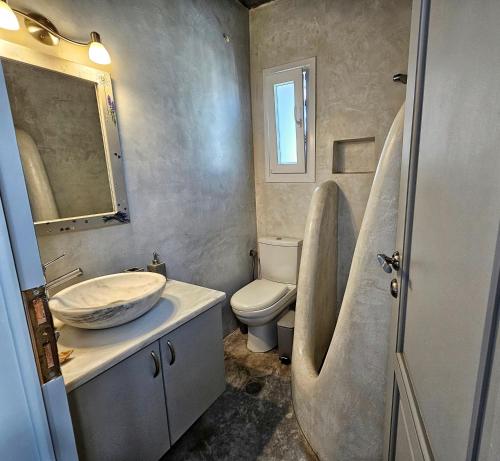 a bathroom with a sink and a toilet at Sea-View Rooftop Terrace Studio in Pánormos