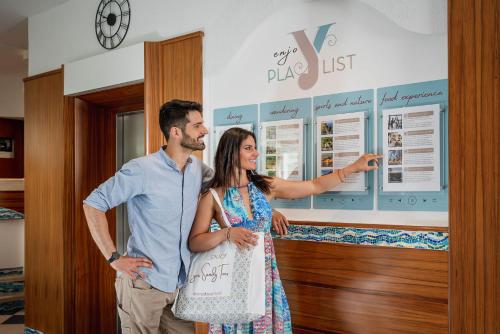 a man and a woman standing in front of a poster at Luxor Beach Boutique Hotel Cattolica in Cattolica