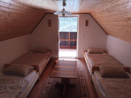 a attic room with three beds and a window at Wooden Treasure in Jesenice