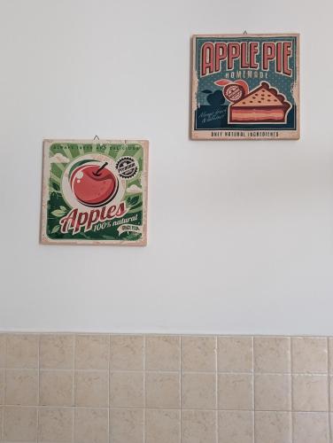two signs on the wall of a bathroom with apple pie at Gemma del mare in Crotone