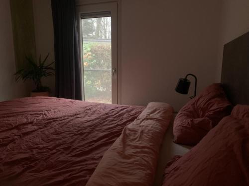 een slaapkamer met een bed en een raam bij Bospark Ede Huisje 31 in Ede