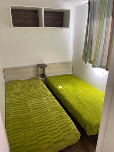 a bedroom with two beds with green sheets at Bungalow Martins Nazaré Land`s Hause in Pataias