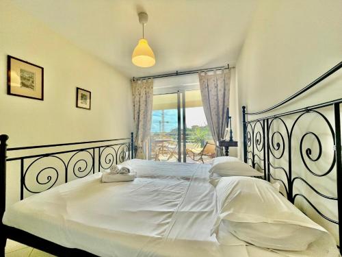 une chambre avec un grand lit blanc et une fenêtre dans l'établissement 2 Rooms In Luxury Residence Bordering Monaco, à Beausoleil