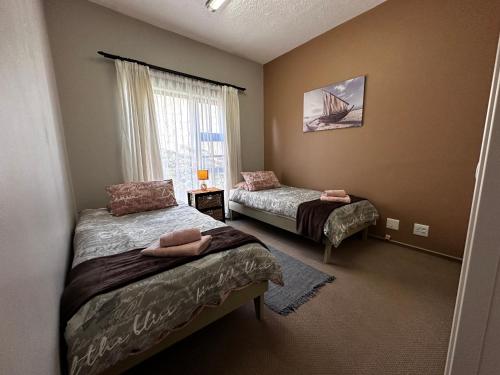 a bedroom with two beds and a window at Astra Self-Catering Apartments in Swakopmund