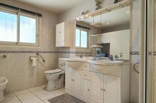 a bathroom with a sink and a toilet and a mirror at Villa à 200 m de la plage in Fréjus