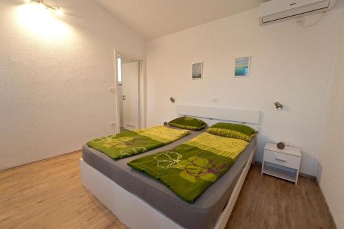 ein Schlafzimmer mit einem großen Bett mit grüner Bettwäsche in der Unterkunft Ferienhaus für 6 Personen und 2 Kinder in Pula, Istrien Istrische Riviera in Pula
