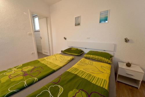 1 Schlafzimmer mit 2 Betten mit grüner und gelber Bettwäsche in der Unterkunft Ferienhaus für 6 Personen und 2 Kinder in Pula, Istrien Istrische Riviera in Pula