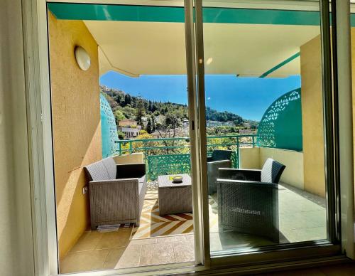 a balcony with chairs and a view from a window at quiet studio swimming pool Roquebrune in Roquebrune-Cap-Martin