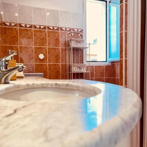 La salle de bains est pourvue d'un lavabo et d'une baignoire. dans l'établissement Beautiful Apartment Near Monaco, à Beausoleil