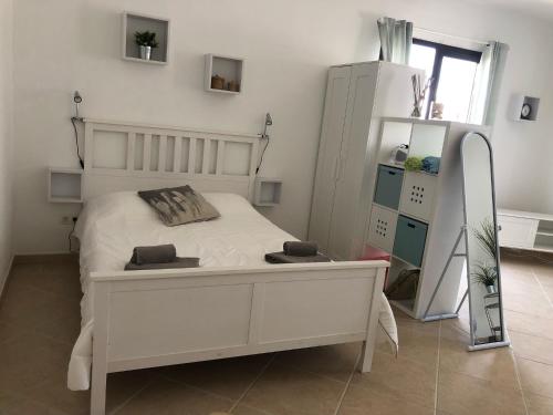 a bedroom with a white bed and a mirror at Las Buganvillas 77 in Playa Blanca