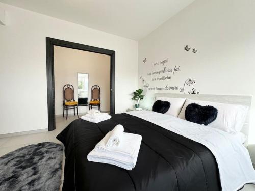 een slaapkamer met een groot zwart bed en 2 stoelen bij Attico Magnificent [Wi-Fi/Free Parking] in Palermo