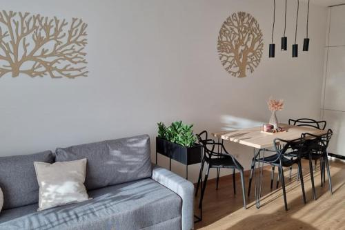 a living room with a couch and a table with chairs at M&M2 Brand new apartment near center with parking in Košice