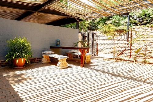 a patio with a wooden table and benches on it at Waters on Willows in Pretoria