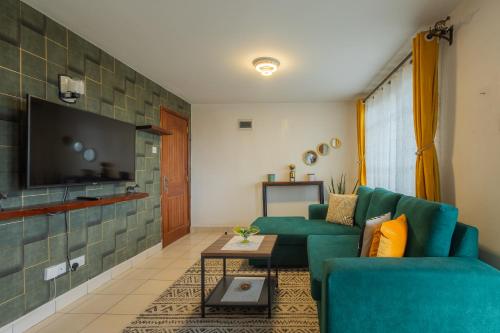Furnished 1 Bedroom Apartment in Nairobi. 15 Mins to CBD. Free WI-FI & Parking في نيروبي: غرفة معيشة مع أريكة خضراء وتلفزيون
