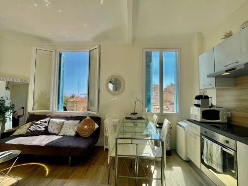 ein Wohnzimmer mit einem Sofa und einem Tisch in der Küche in der Unterkunft Charming T2 - 2 Minutes Walk From Monaco in Beausoleil