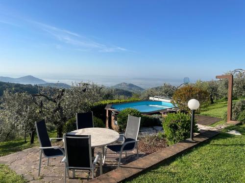 a patio with a table and chairs and a pool at Podere il Poggio in Avaglio