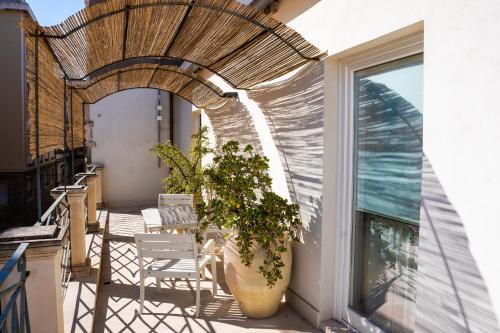 a balcony with chairs and a potted plant at San Giuseppe apartment con Terrazza in Siracusa