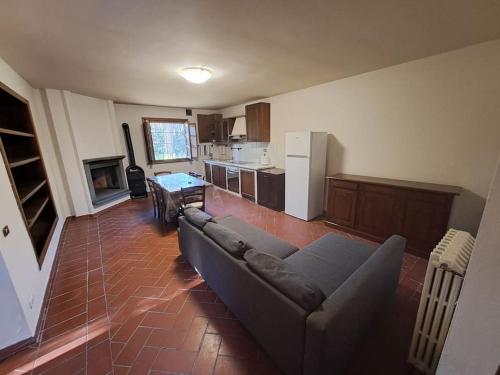 a living room with a couch and a kitchen at Podere Travalda - appartamento in agriturismo per 4-6 persone in Pontedera