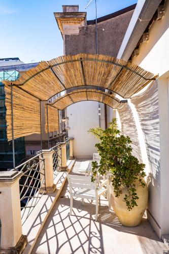 a patio with chairs and an umbrella on a building at San Giuseppe apartment con Terrazza in Siracusa