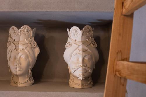two white vases are sitting on a shelf at San Giuseppe apartment con Terrazza in Siracusa