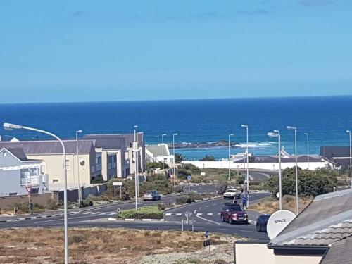 una calle con coches conduciendo por una carretera junto al océano en Dolphin Ridge, en Ciudad del Cabo