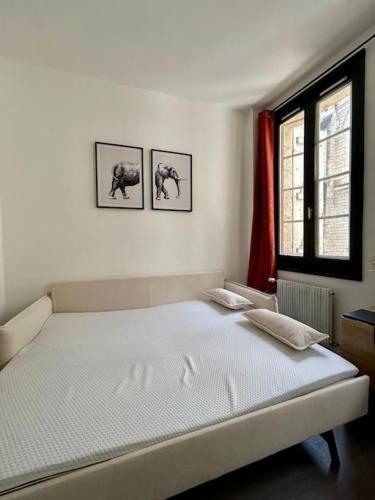 - un lit dans une chambre avec 3 photos sur le mur dans l'établissement Studio Angoulême centre, à Angoulême