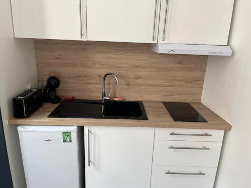 - une cuisine avec un évier et des placards blancs dans l'établissement Studio Angoulême centre, à Angoulême