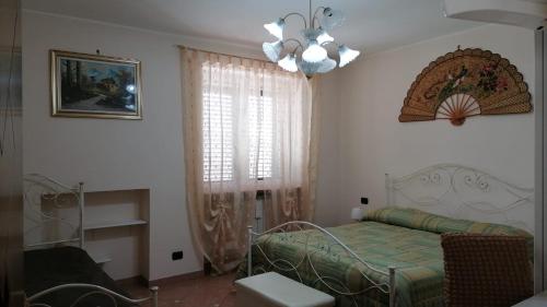 - une chambre avec un lit et un lustre dans l'établissement DIMORA ANTONIANNA in VALLE D'ITRIA, à Locorotondo