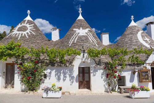 une maison blanche avec un toit orné de plantes à fleurs dans l'établissement Appartamento in Salento, à San Vito dei Normanni