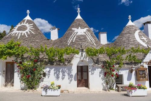 a white house with a roof with flowering plants at Appartamento in Salento in San Vito dei Normanni