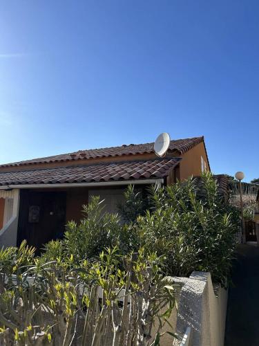 une maison avec beaucoup de plantes devant elle dans l'établissement HOLIDAYLAND 429 VILLA T2 MEZZANINE 6 couchages climatisé NARBONNE PLAGE, à Narbonne-Plage