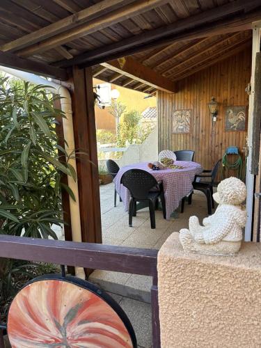 un patio avec une table et des chaises sur un porche dans l'établissement HOLIDAYLAND 429 VILLA T2 MEZZANINE 6 couchages climatisé NARBONNE PLAGE, à Narbonne-Plage
