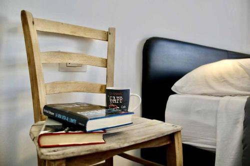 a stack of books on a chair next to a bed at Casa del Tempo Irma Tassullo Ospitar in Tassullo